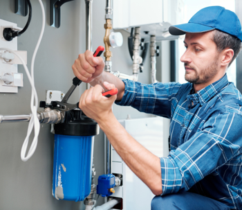 Plumber installing home water filter