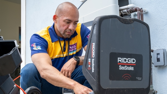 Technician performing HD sewer scope inspection with Ridgid SeeSnake